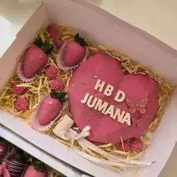 A pink Heart Box With Small Chocolate Pieces Inside